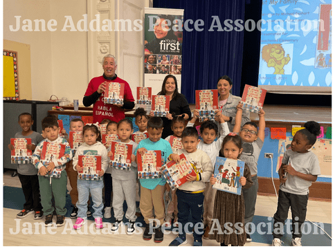michael genhart and elementary school age students holding the book spanish is the language of my family red